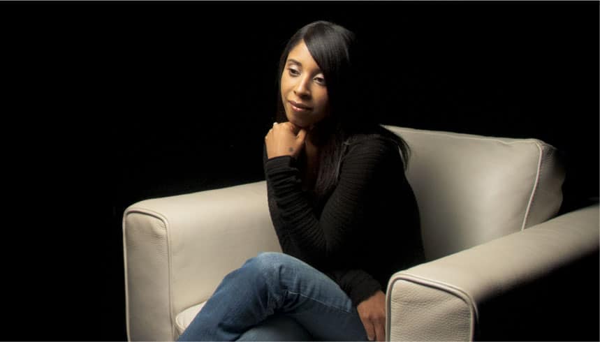 Lilly Goodman sitting down while crossing legs in the white chair